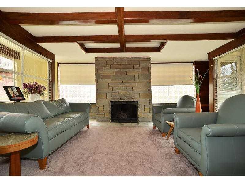 Living Room. Natural light fills the living room all day long  and at night gather around the flag stone fireplace. From the living room there is a man door that leads to the back yard.