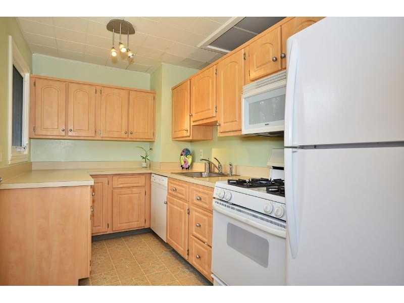 Kitchen. Newer maple kitchen with gas stove, dishwasher, refrigerator. There is a door from this room to the large rear yard.