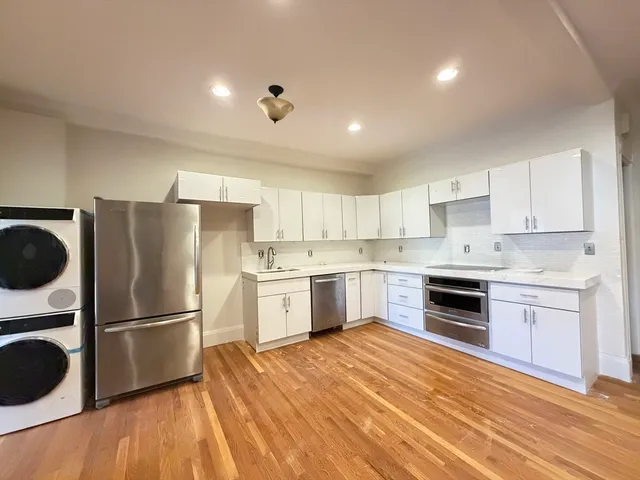 a kitchen with a refrigerator stove and white cabinets