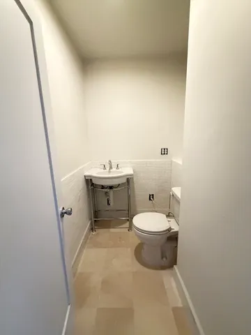a bathroom with a toilet a sink and a mirror