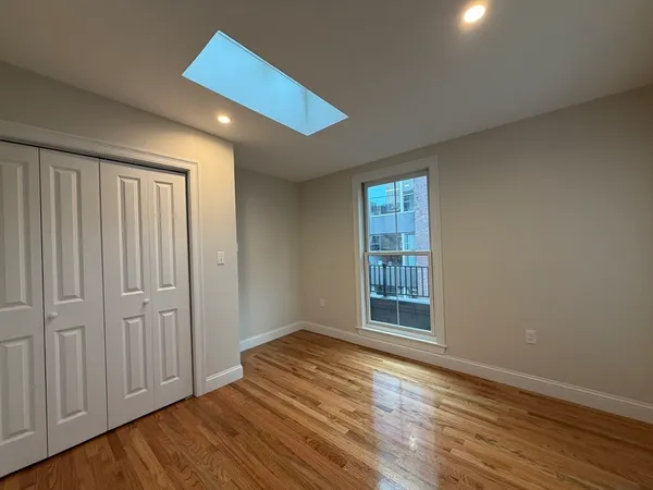 an empty room with wooden floor and fireplace
