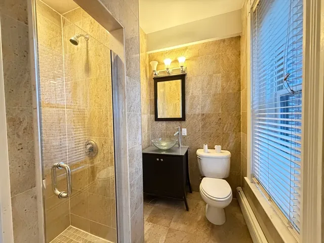 a bathroom with a toilet a sink and shower