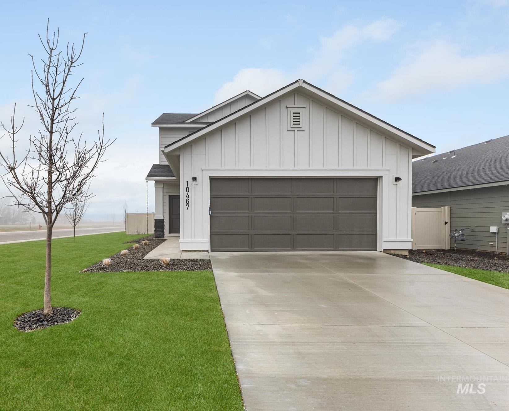 10467 West Tinder Street Star, ID 83669 - Photo 2 of 21 View of front of house featuring board and batten siding, driveway, a front lawn, and a garage