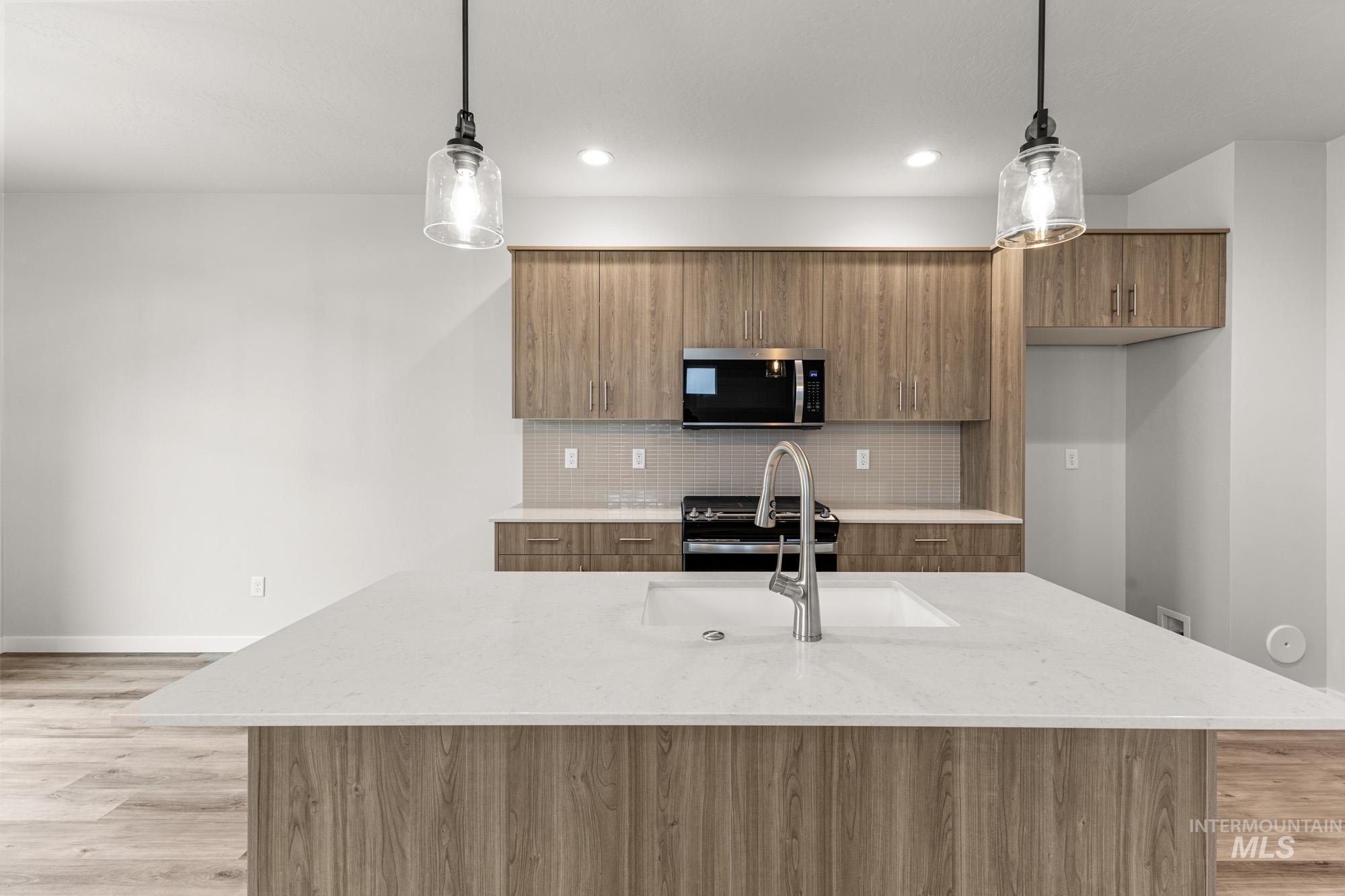 10467 West Tinder Street Star, ID 83669 - Photo 4 of 21 Kitchen featuring modern cabinets, light wood-type flooring, and light stone counters