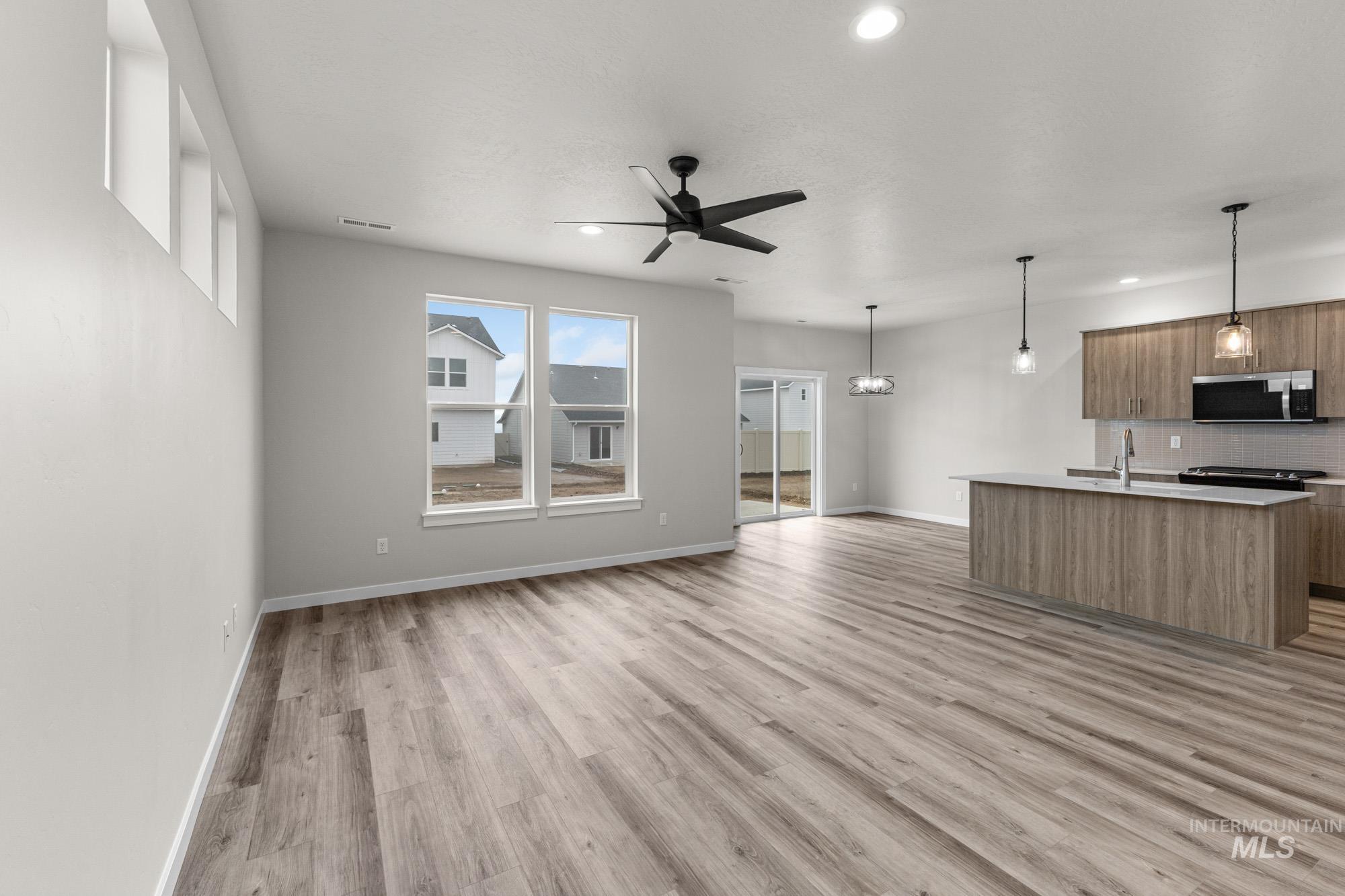 10467 West Tinder Street Star, ID 83669 - Photo 7 of 20 Unfurnished living room featuring ceiling fan, light wood-style flooring, recessed lighting, and a chandelier