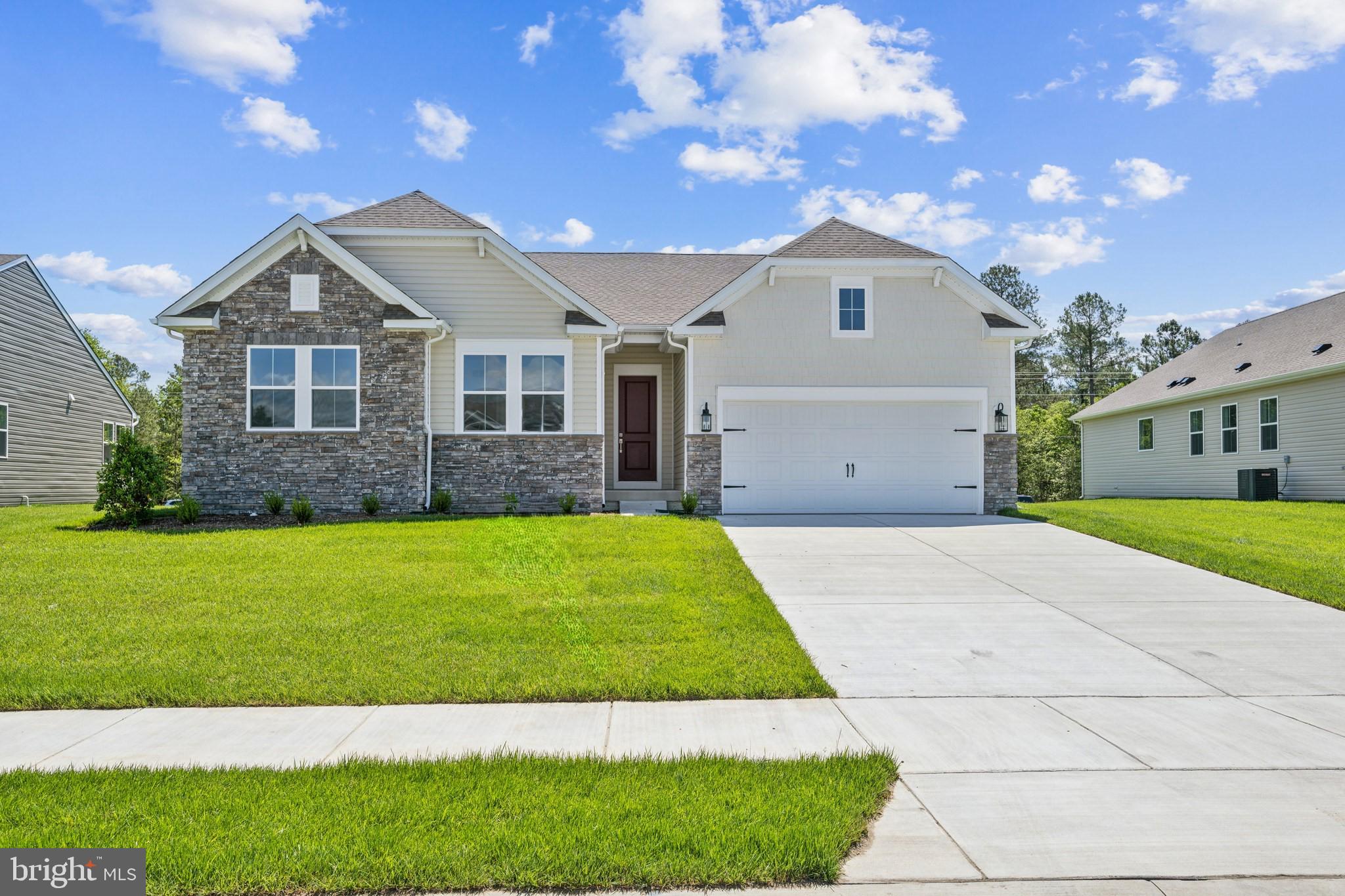 a front view of a house with a garden and yard