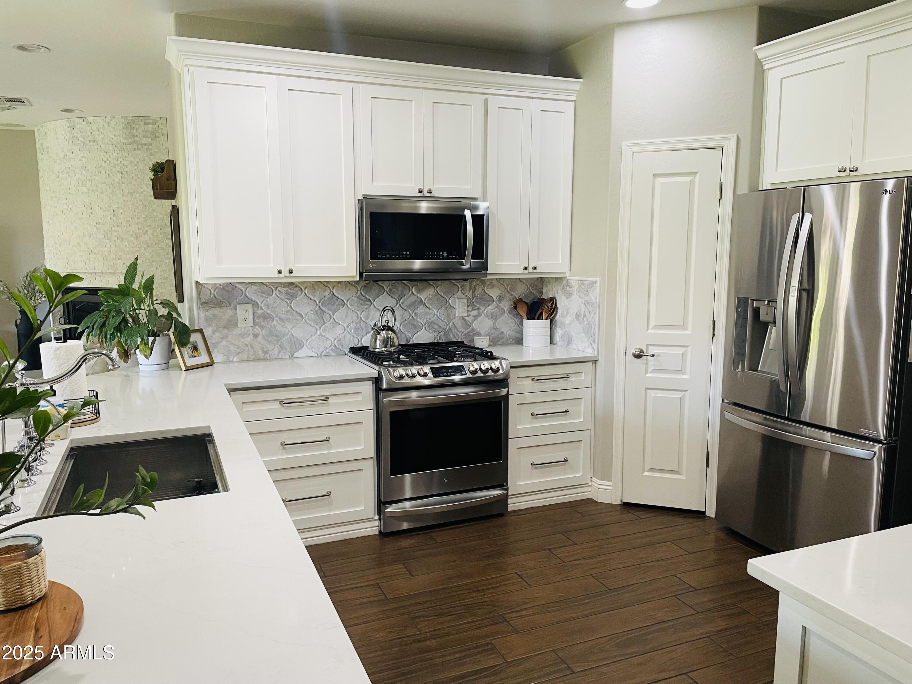 11411 East Sebring Circle Mesa, AZ 85212 - Photo 49 of 87 a kitchen with granite countertop white cabinets and stainless steel appliances