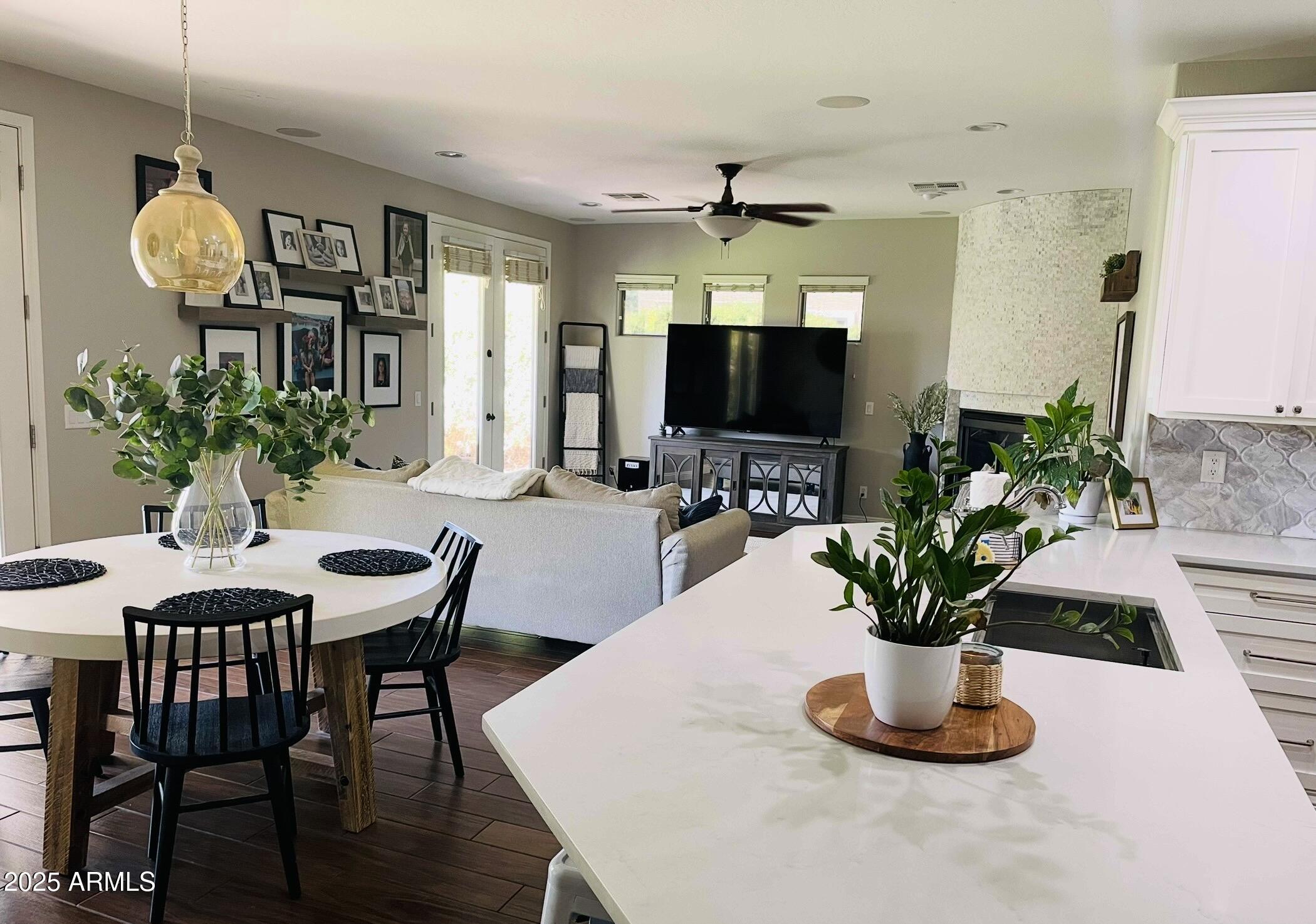 11411 East Sebring Circle Mesa, AZ 85212 - Photo 57 of 87 a dining room with furniture a potted plant and a flat screen tv