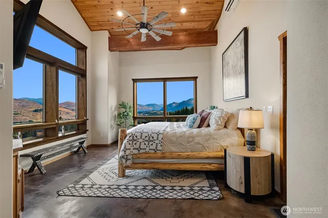 a bedroom with a bed a mirror and windows