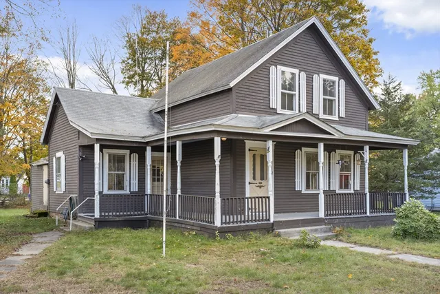 a view of a house with a yard and large tree