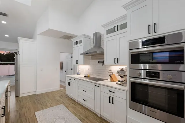 a kitchen with stainless steel appliances a refrigerator and a stove top oven