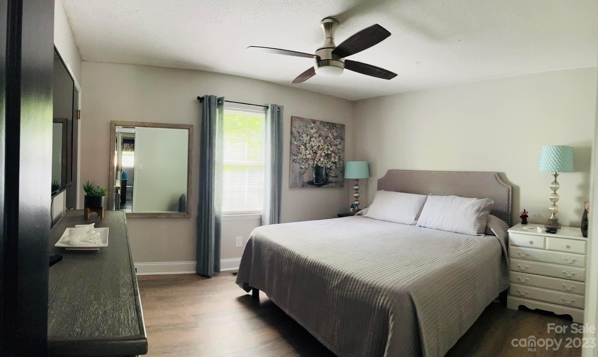 3001 Beaty Road Gastonia, NC 28056 - Photo 8 of 15 a bedroom with a large bed and a chandelier