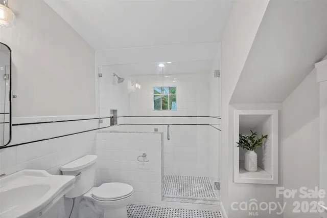 a bathroom with a toilet a sink and shower