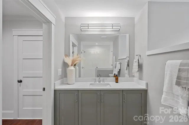 a bathroom with a double vanity sink mirror and shower