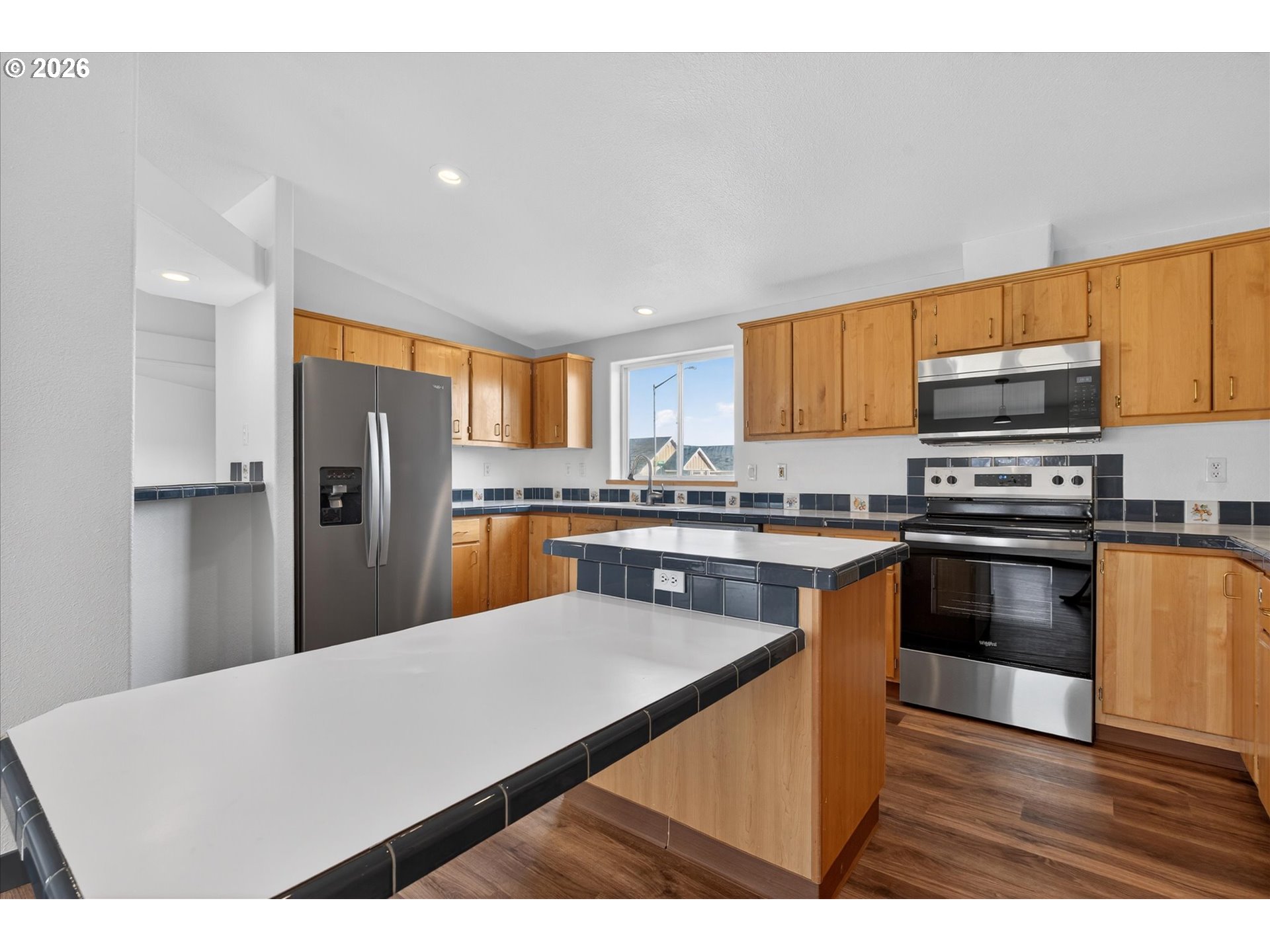 208 16th Street La Grande, OR 97850 - Photo 12 of 42 a kitchen with stainless steel appliances a refrigerator a stove a sink dishwasher and a microwave with wooden floor