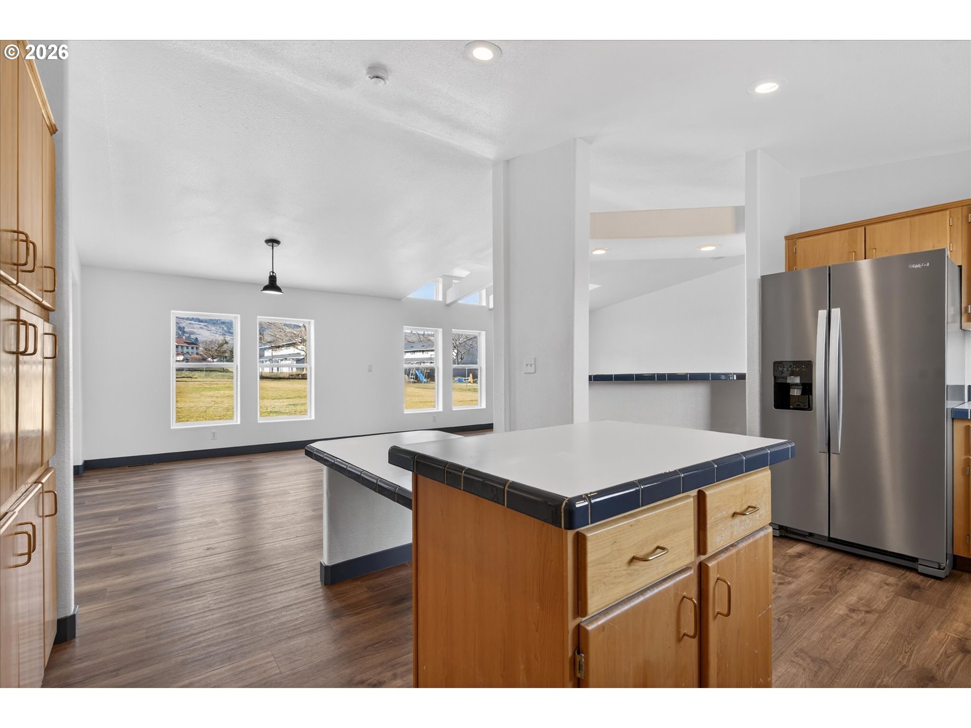 208 16th Street La Grande, OR 97850 - Photo 14 of 42 a kitchen that has a kitchen island wooden cabinets and refrigerator