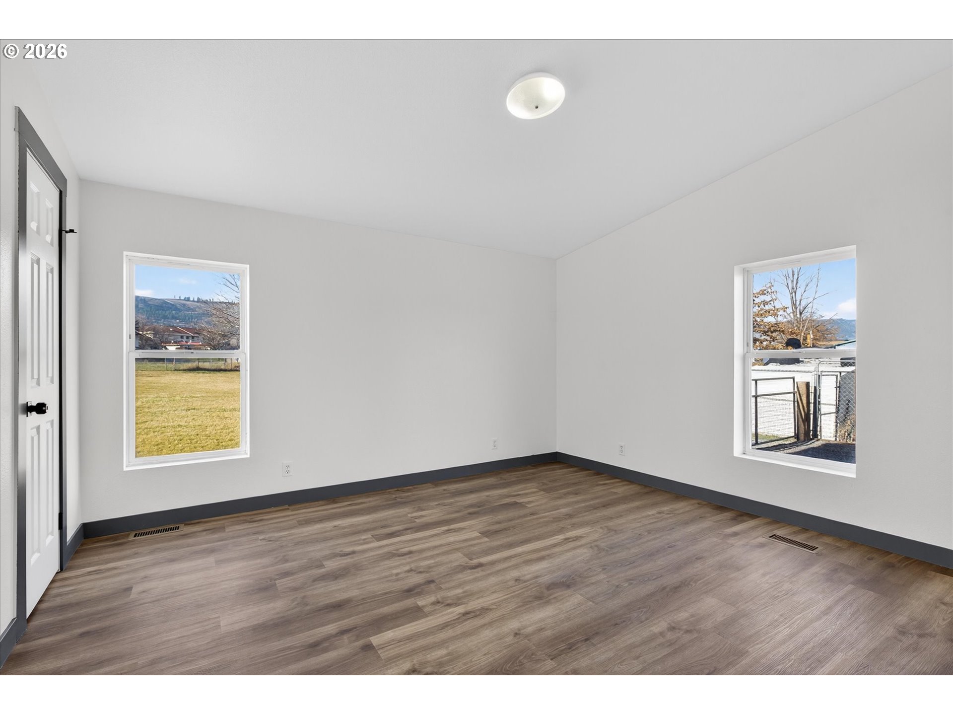 208 16th Street La Grande, OR 97850 - Photo 18 of 42 a view of an empty room with a window and wooden floor