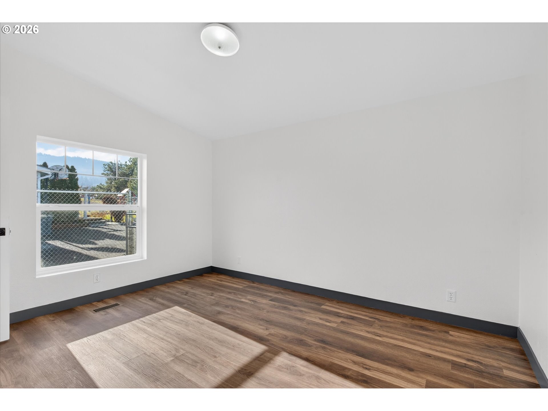 208 16th Street La Grande, OR 97850 - Photo 24 of 42 a view of an empty room with wooden floor and a window