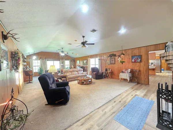 a view of an empty room with furniture and a large window