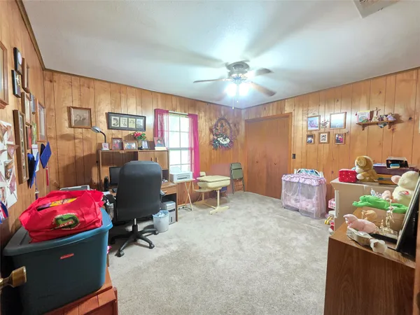 a spacious bedroom with a bed a chair and a chandelier