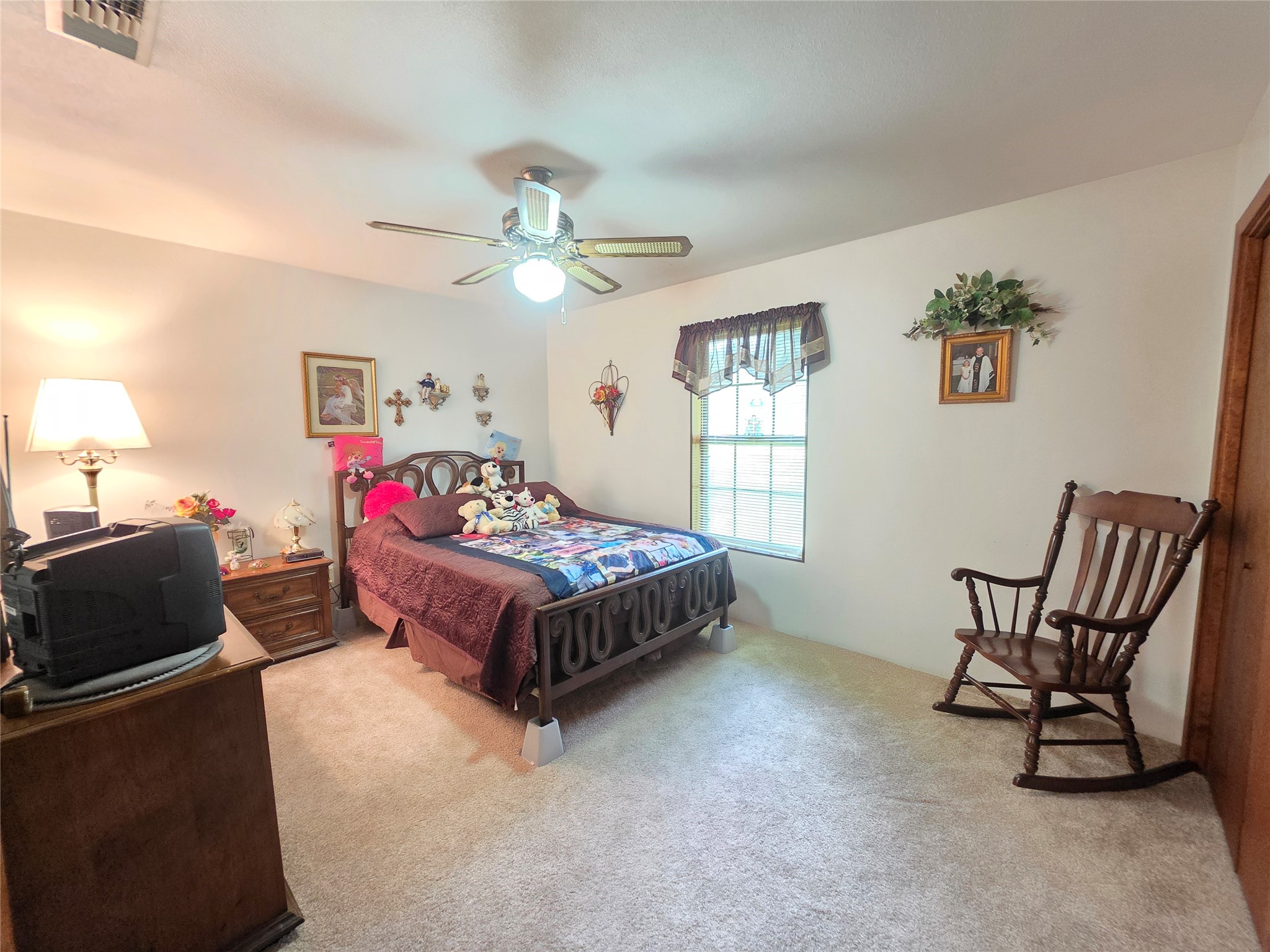 406 Wilson Creek Road Palacios, TX 77465 - Photo 30 of 49 a spacious bedroom with a bed a chair and a chandelier