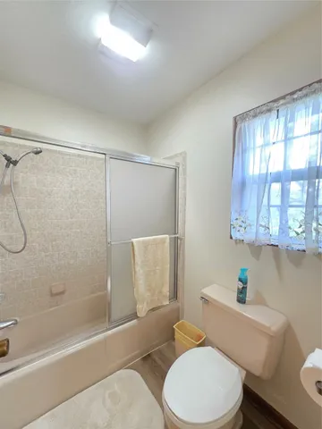 a bathroom with a granite countertop sink a toilet a mirror and shower
