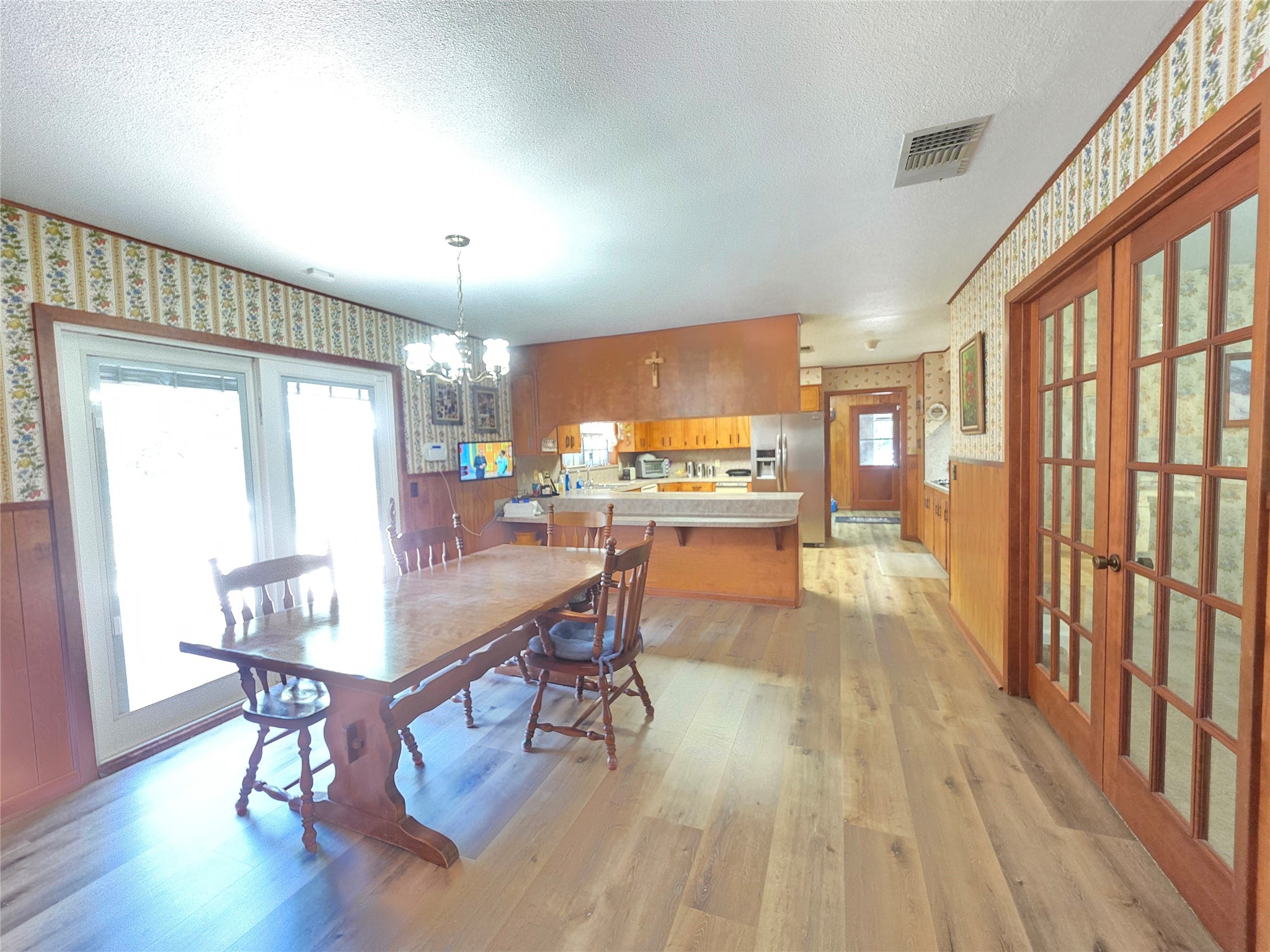 406 Wilson Creek Road Palacios, TX 77465 - Photo 36 of 49 a dining room with wooden floor a chandelier a wooden table and chairs