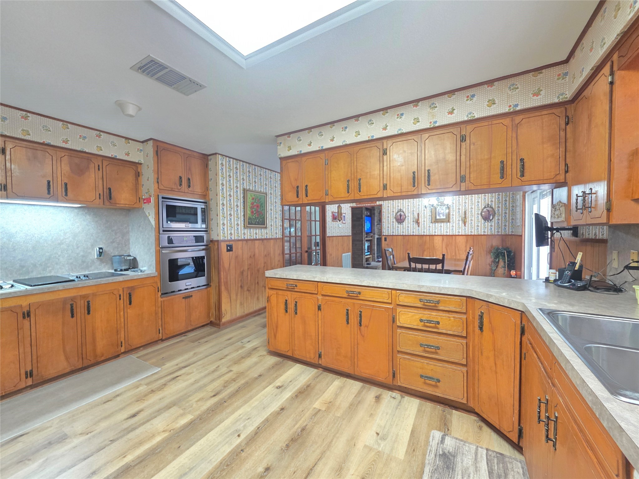 406 Wilson Creek Road Palacios, TX 77465 - Photo 38 of 49 a large kitchen with stainless steel appliances wooden cabinets a center island and a stove top oven
