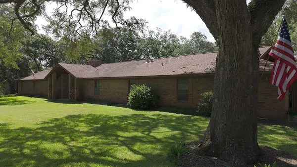 a view of a house with a yard and tree