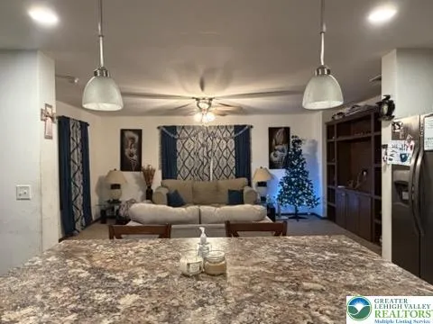 a kitchen with stainless steel appliances granite countertop a stove top oven a sink dishwasher a dining table and chairs