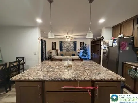 a kitchen with a dining table chairs and refrigerator