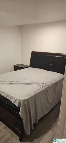 a spacious bedroom with a bed and dresser