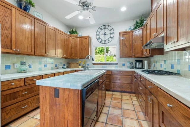 a kitchen with granite countertop a sink a stove and cabinets