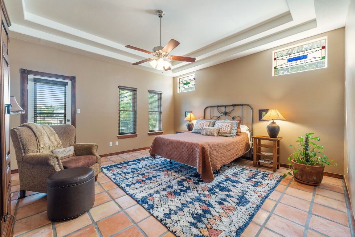 16312 Lake Loop Austin, TX 78734 - Photo 21 of 36 a bedroom with a bed a rug and a chandelier