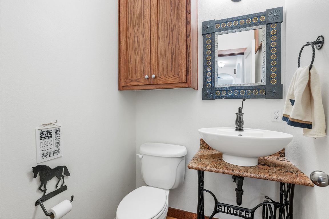 16312 Lake Loop Austin, TX 78734 - Photo 32 of 36 a bathroom with a toilet a sink and mirror