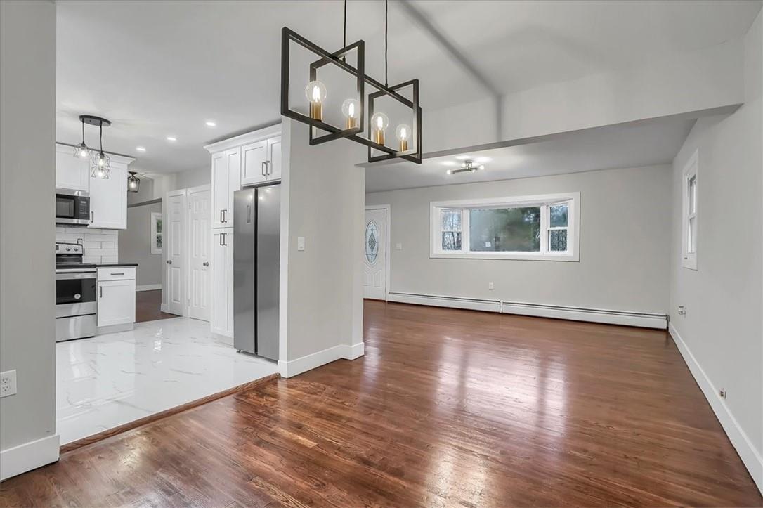 a view of a kitchen with a refrigerator and a stove top oven