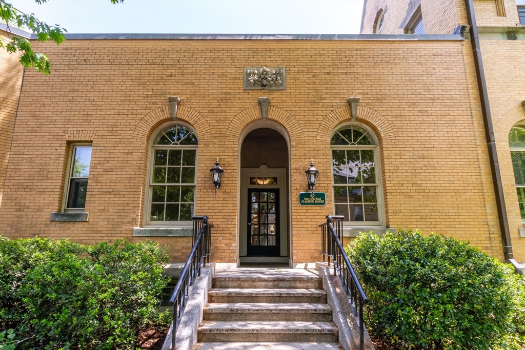 60e Glen Road, Unit 306 Brookline, MA 02445 - Photo 1 of 27 a front view of a house with a garden