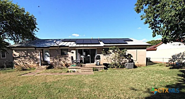 a view of a chairs and table in front of house