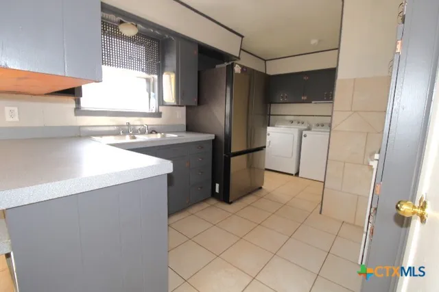 a kitchen with a refrigerator sink and cabinets