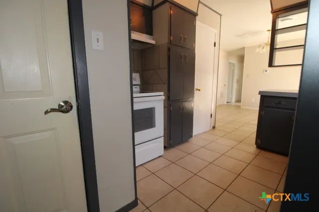 a kitchen with a refrigerator and a stove top oven
