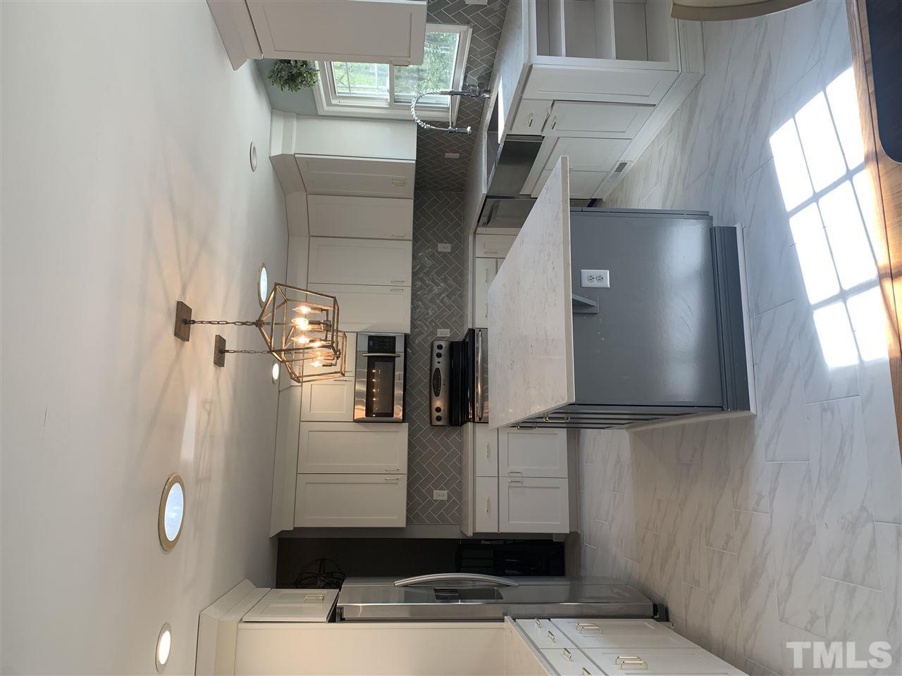 4931 Oak Park Road Raleigh, NC 27612 - Photo 3 of 10 a kitchen with kitchen island granite countertop cabinets and refrigerator