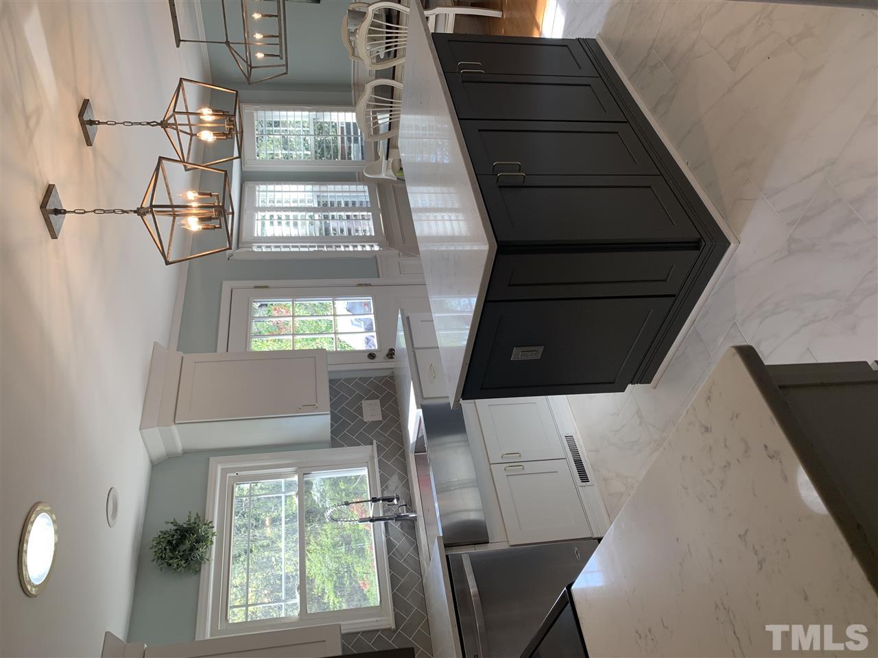 4931 Oak Park Road Raleigh, NC 27612 - Photo 4 of 10 a kitchen with kitchen island granite countertop a sink window and cabinets