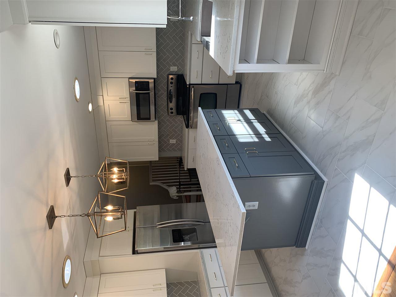 4931 Oak Park Road Raleigh, NC 27612 - Photo 5 of 10 a kitchen with stainless steel appliances kitchen island granite countertop a stove a sink and a microwave