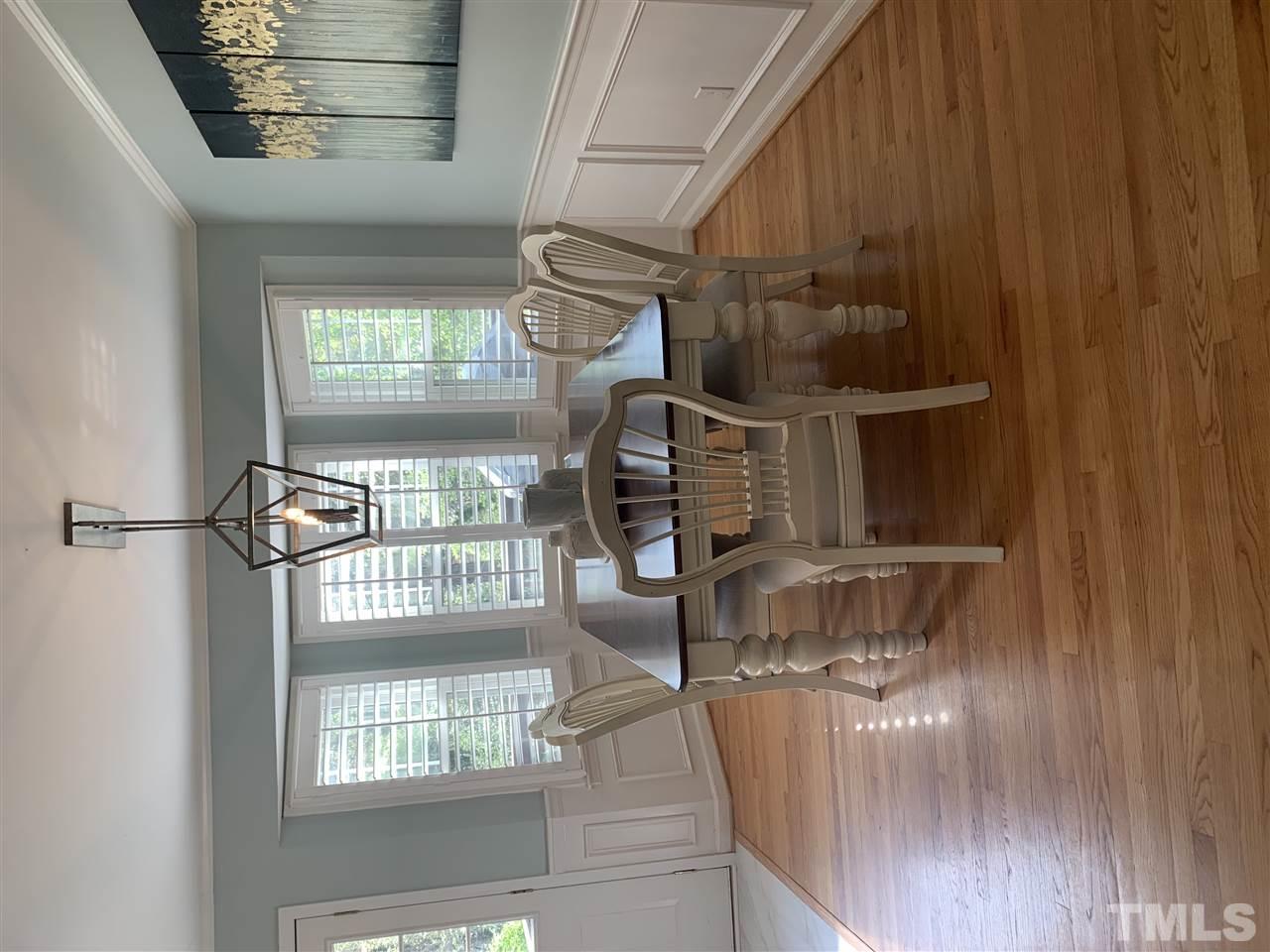 4931 Oak Park Road Raleigh, NC 27612 - Photo 6 of 10 a dining room with furniture a chandelier and wooden floor