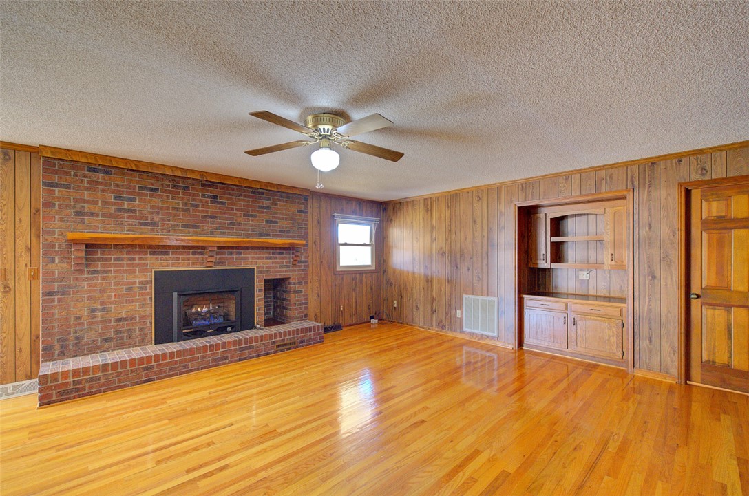 130 Raleighs Lane West Union, SC 29696 - Photo 10 of 49 Gleaming hardwood floors and a brick fireplace anchor this classic living space.