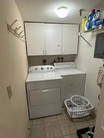 a spacious bedroom with a bed and a flat tv screen on the dresser