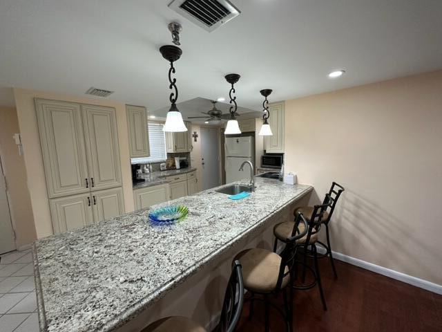6500 Northwest 2nd Avenue, Unit 512 Boca Raton, FL 33487 - Photo 10 of 41 a kitchen with kitchen island a wooden floor and chairs