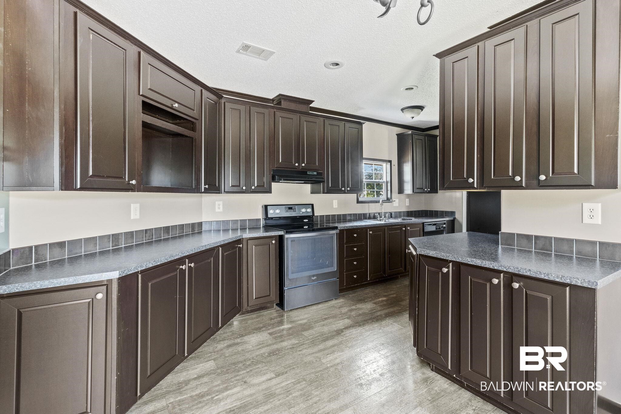 6870 Cecilia Court Theodore, AL 36582 - Photo 18 of 83 Kitchen featuring a textured ceiling, range with electric stovetop, dark brown cabinetry, and light hardwood / wood-style flooring