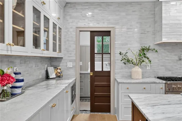 a bathroom with a granite countertop white sink and a potted plant