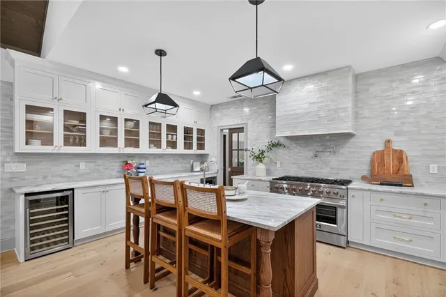 a living room with furniture kitchen view and a chandelier